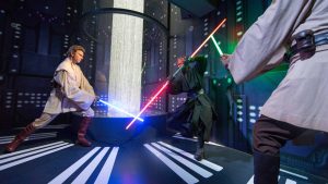 Wax figures of Star Wars characters, Luke Skywalker and Darth Vader, are fighting with blue and red lightsabers.